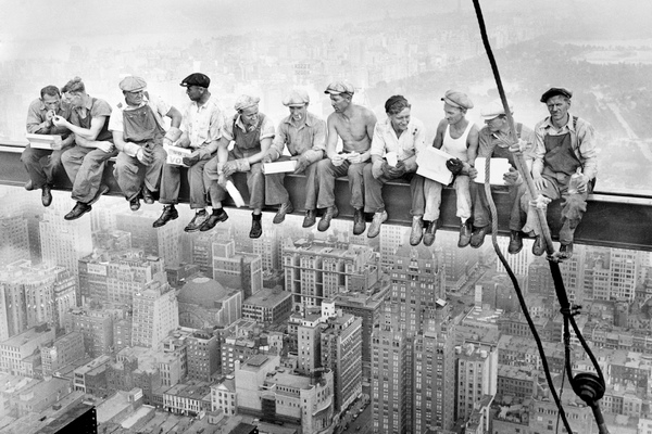 La storica fotografia del 1932 in bianco e nero con gli uomini operai che pranzano sopra la trave sospesa del grattacielo in costruzione Rockefeller Center, sopra la città di New York