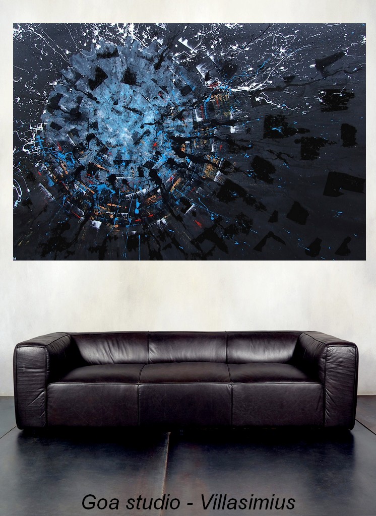 Un quadro su tela firmato pittore Goa, posizionato su di una parete color panna sopra ad un divano in pelle di nera e pavimento in grosse lastre di cemento spatolato grigio scuro
