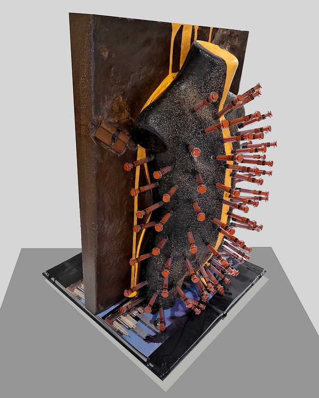 SCULTURA MODERNA REALIZZATA CON MATERIALE DI RECUPERO E DI RICICLO. LA BASE DELL'OPERA E' REALIZZATA CON UN LIBRO DEDICATO ALL'ATTACO DELL'11 SETTEMBRE. SOPRA AD ESSO UN BUSTO DI UN BAMBINO E' COSTELLATO DI SIRINGHE IN VETRO. NELLA SCHIENA DELLA SCULTURA SONO AFFOGATE IN UN MURO DIVISORIO DI CEMENTO DELLE SERRATURE IN METALLO.