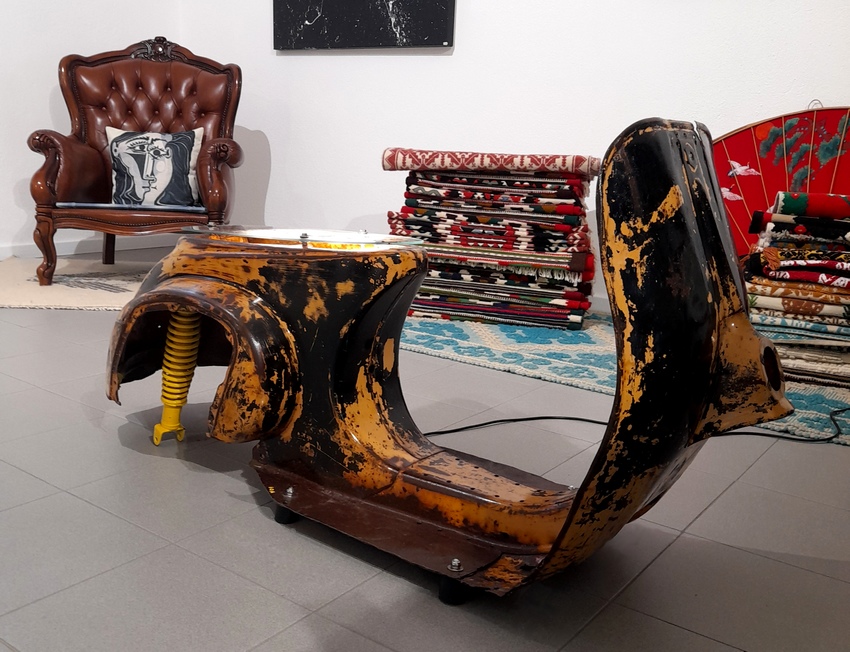 Questa scultura è stata realizzata col telaio di una Vespa d'epoca 50 special. La sua patina color ruggine le dona una linea elegante ed al tempo stesso contemporanea e moderna. Grazie ad un impianto elettrico, la scultura diventa una lampada da pavimento che trasmette un ampio fascio di luce verso l'alto grazie a due lampade led inserite nel vano sotto sella. Scultura moderna dedicata a tutti coloro che amano l'old stile ed il vintage; scultura che donerà un tocco unico all'arredamento di una casa moderna.