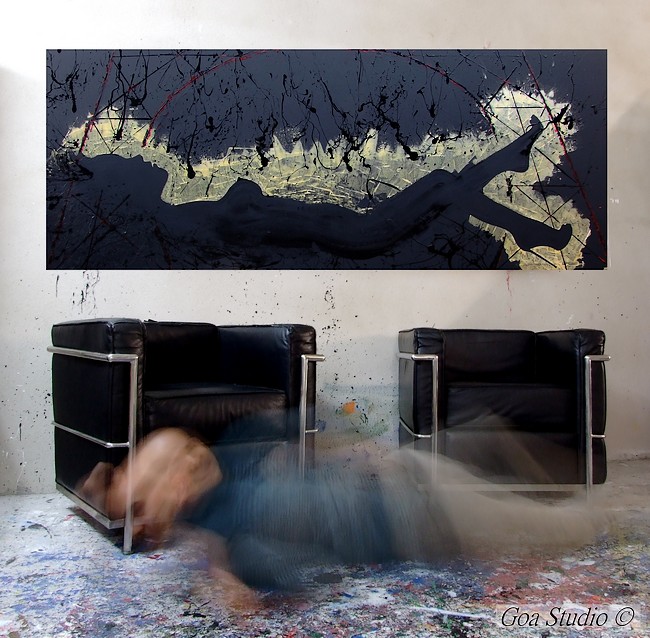 Fabrizio Sanna in arte Goa è nel suo studio con il pavimento dipinto in dripping e il quadro con la donna nuda a parete
