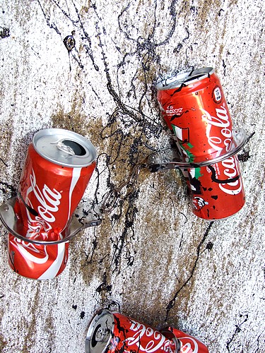 INGRANDIMENTO DELL'ACCUMULAZIONE ASTRATTA CON LE LATTINE DELLA COCA COLA E LE MANETTE IN FERRO