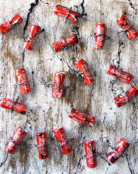 ACCUMULAZIONE ASTRATTA CON LATTINE DI COCA COLA E MANETTE IN FERRO ACCUMULAZIONE ASTRATTA CON LATTINE DI COCA COLA E MANETTE IN FERRO