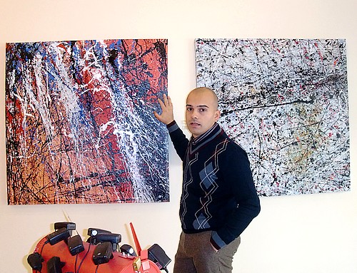 Il pittore sardo Goa vicino a due dipinti della collezione 2010