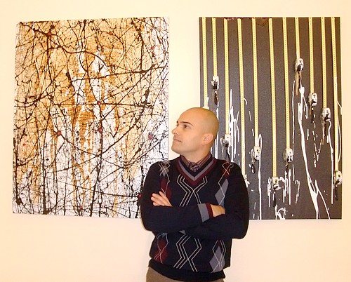L'ARTISTA GOA IN MEZZO A DUE DIPINTI ALLA GALLERIA D'ARTE GOA GALLERY A VILLASIMIUS