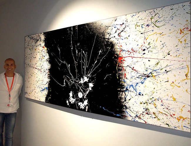 L'ARTISTA CAGLIARITANO FABRIZIO SANNA IN ARTE GOA VICINO AL SUO QUADRO MODERNO CM. 240X100 FINALISTA AL CONCORSO PREMIO MARCHIONNI AL MUSEO MAGMMA
